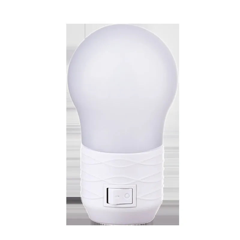 Compact round plug-in bedside lamp in white, blue, or pink for night feeding.