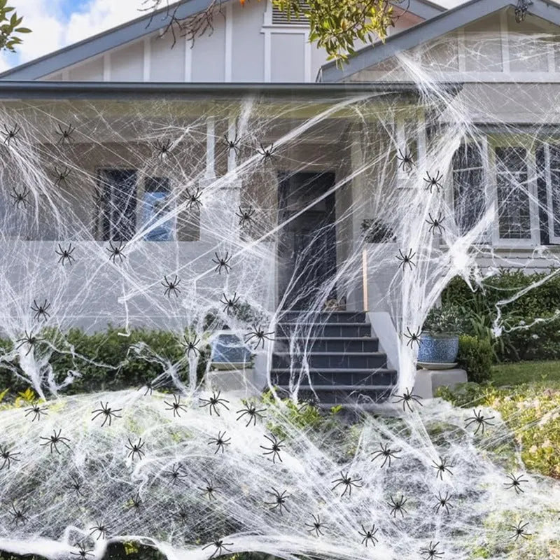 White cotton spider web Halloween decoration with plastic spiders draped over furniture