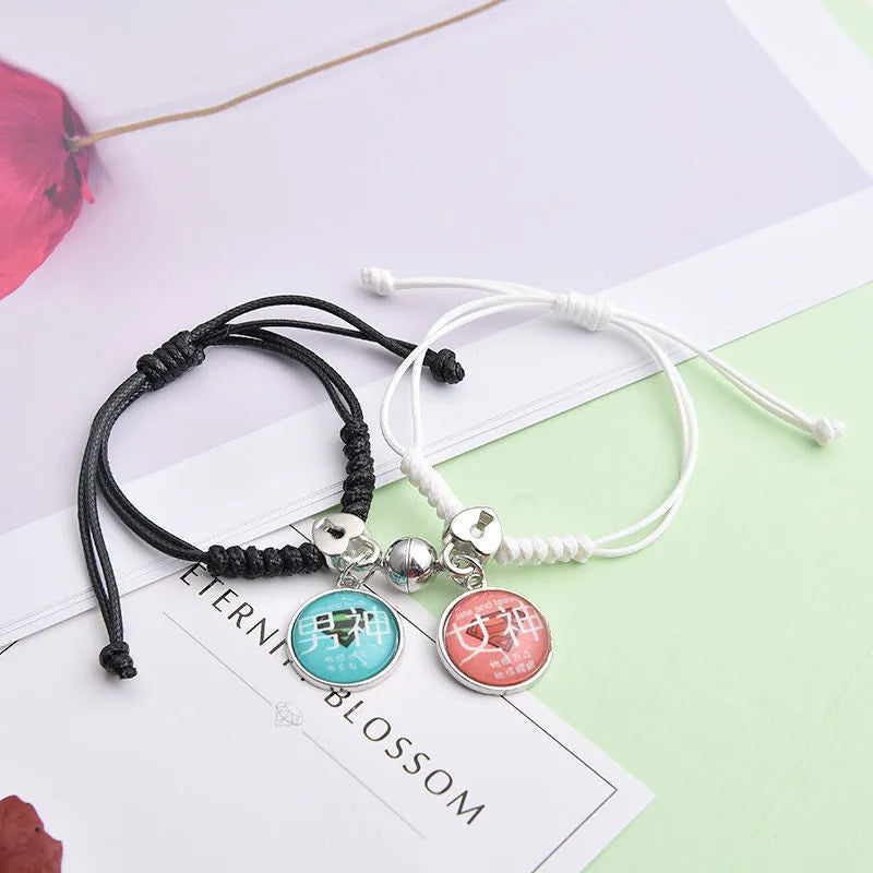 Pair of magnetic suction bracelets with alloy charms in various love and friendship themed designs on a wrist.