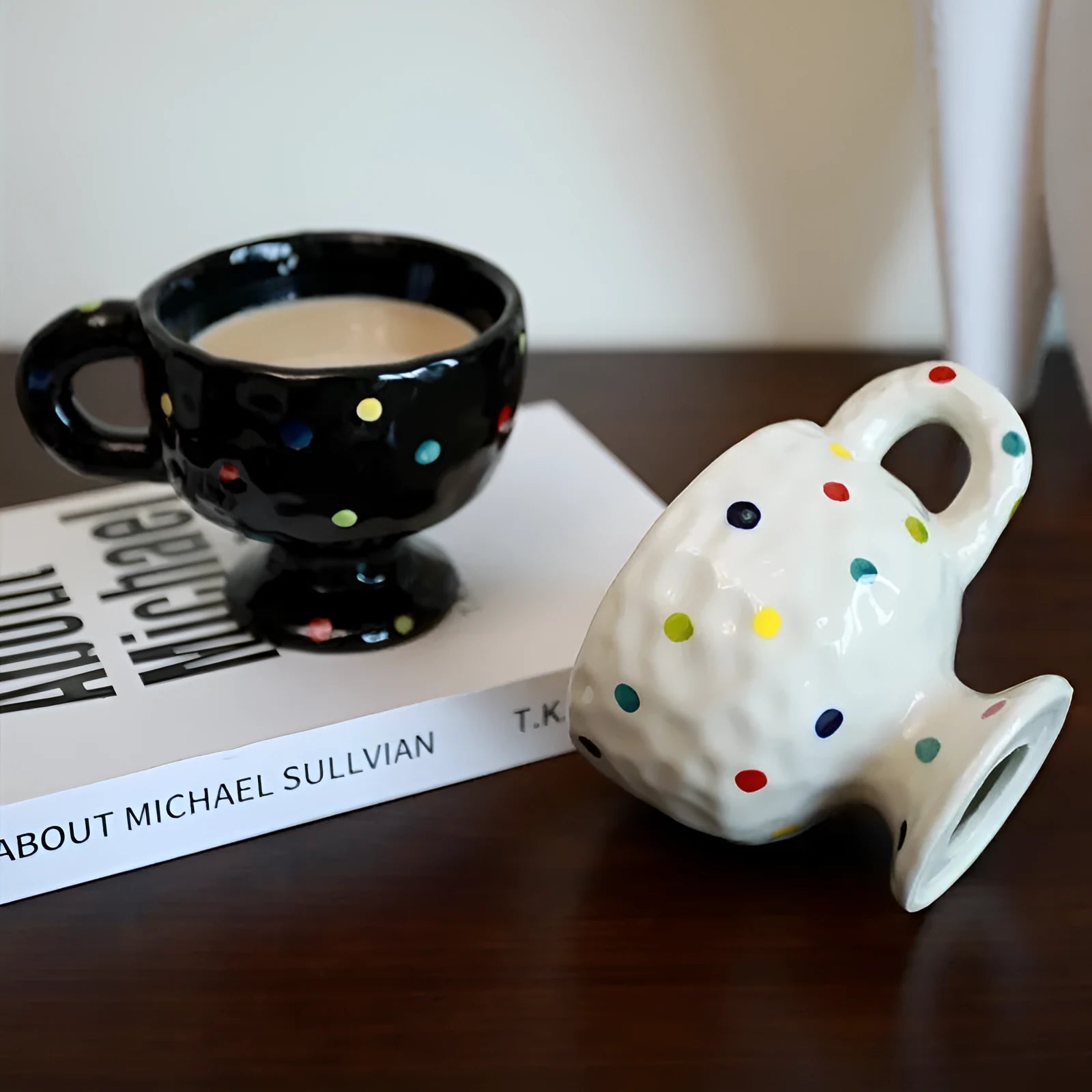 Hand-pinched irregularly shaped ceramic mug in a solid colour, shown on a table.