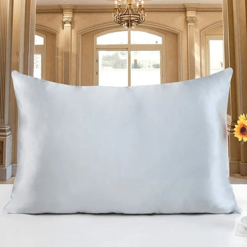 19 M double-sided silk pillowcase in apricot colour on a bed.