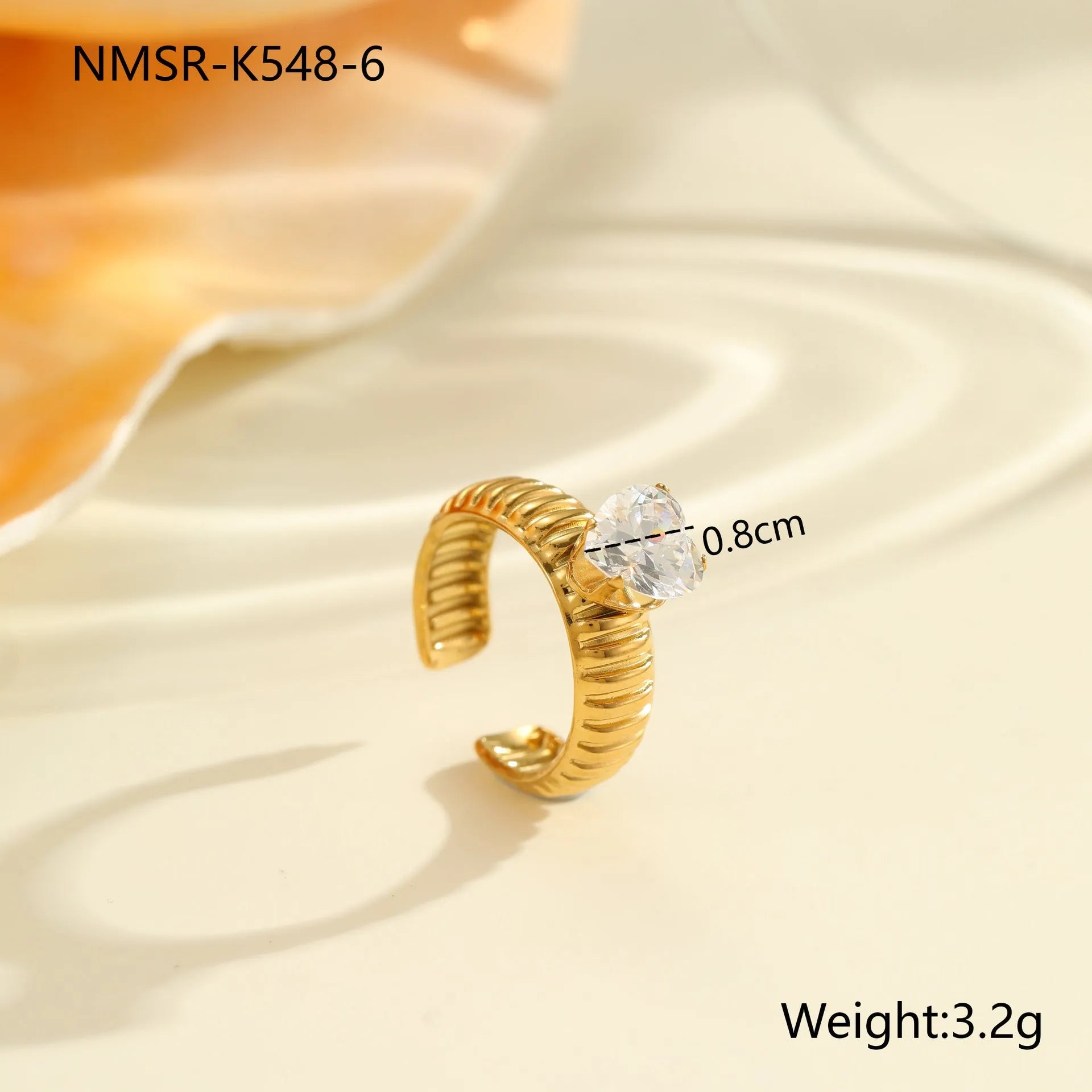 Gold-coloured adjustable stainless steel ring with zircon geometric shapes on white background.