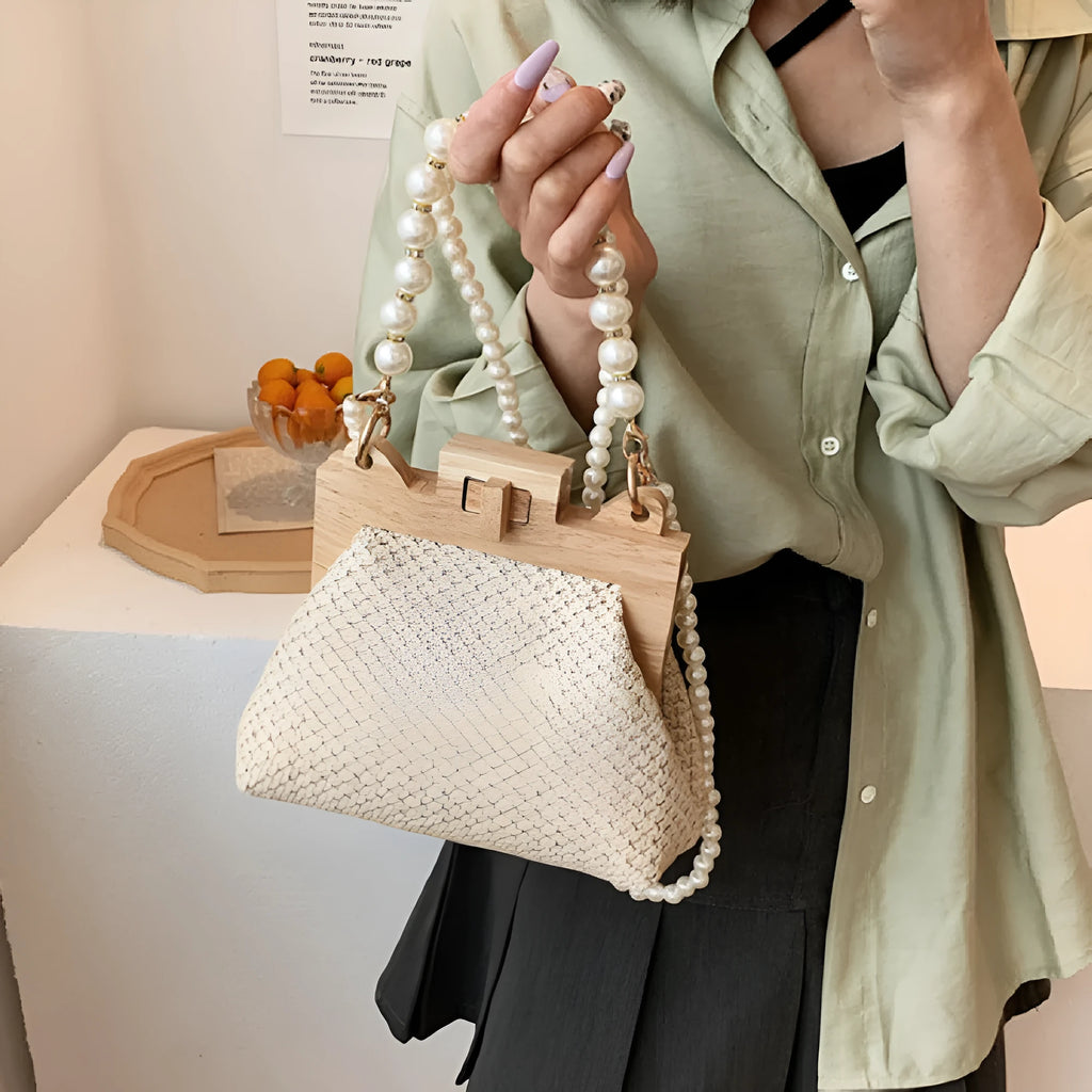 Women's woven straw shoulder bag with pearl chain strap in horizontal square shape showing sandwich pocket detail.
