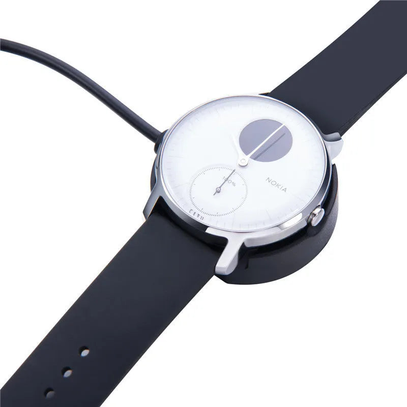 Black Withings Hybrid Smart Watch charging cable with magnetic probe on a desk