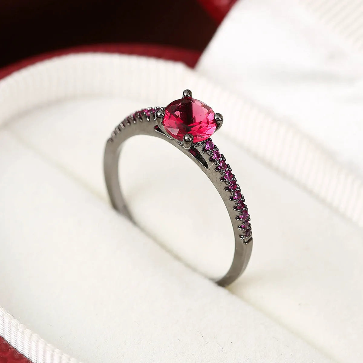 Hexagonal geometric copper ring with zircon electroplating in a gold rose red finish on a hand.