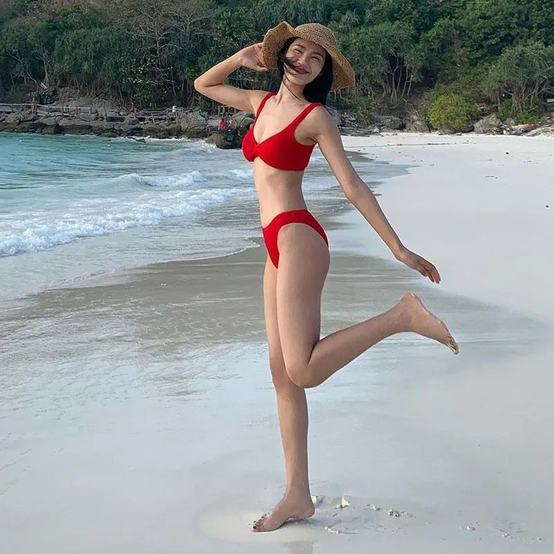 Women's simple split bikini vacation swimsuit in red polyester, sleeveless, shown on a model, available in sizes S M L