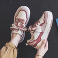 Pink and beige low-top sneakers with rubber soles and height-increasing design