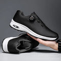 Low-top black and white tennis shoes with mesh uppers, cross shoulder straps, and a flat composite sole.