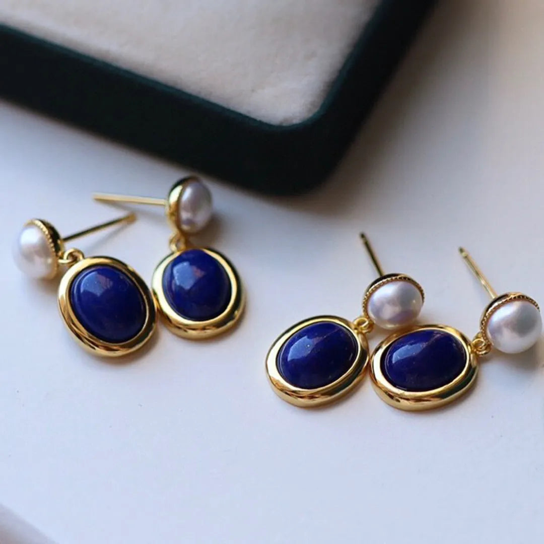 A pair of simple sterling silver drop earrings with a blue lapis lazuli pearl and auspicious patterns.