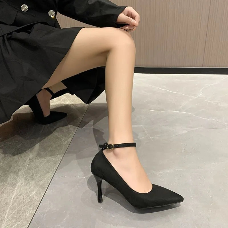Women's black stiletto heel pump with ankle buckle detail and a rubber sole.