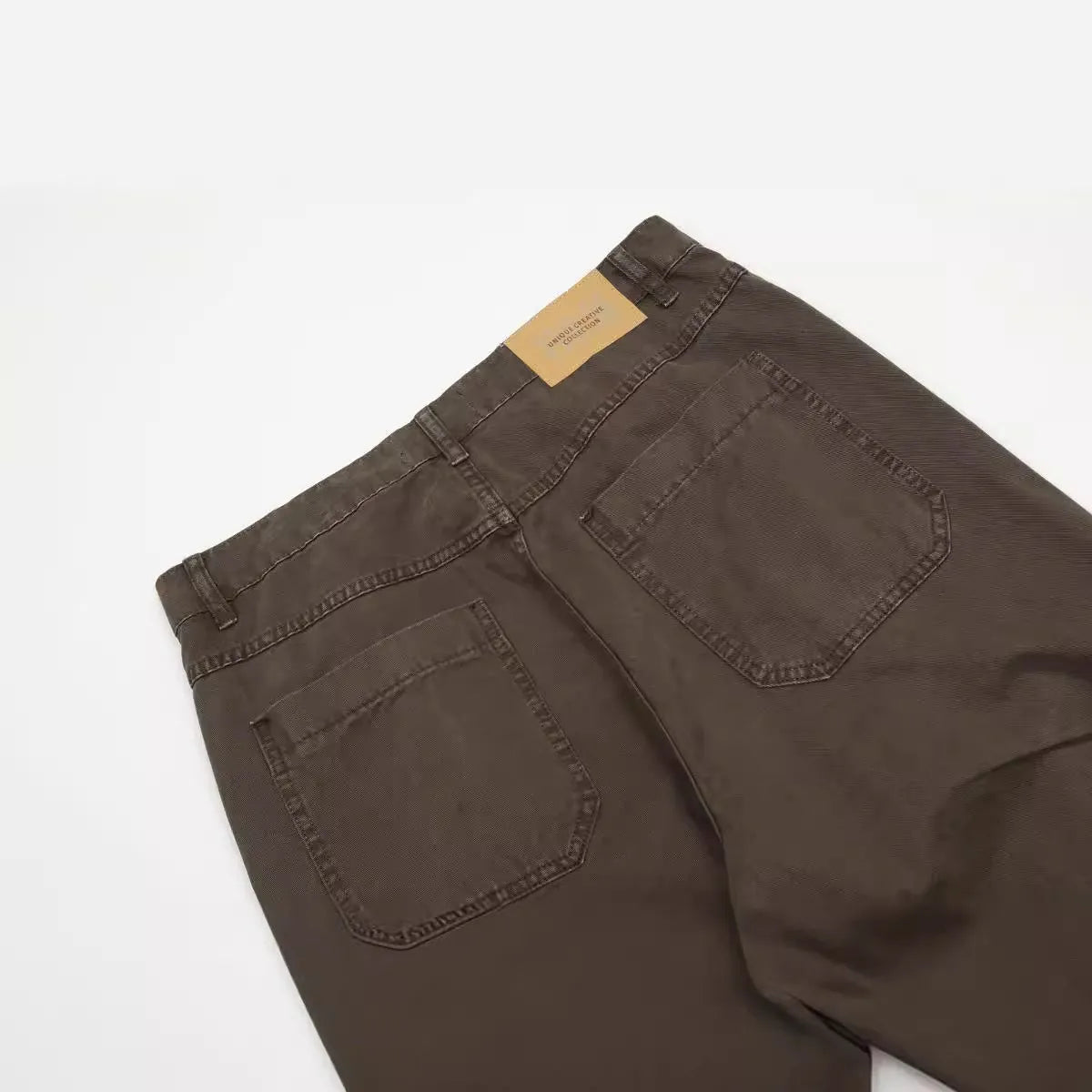 Man wearing brown loose fit high-waist straight leg cotton jeans trousers