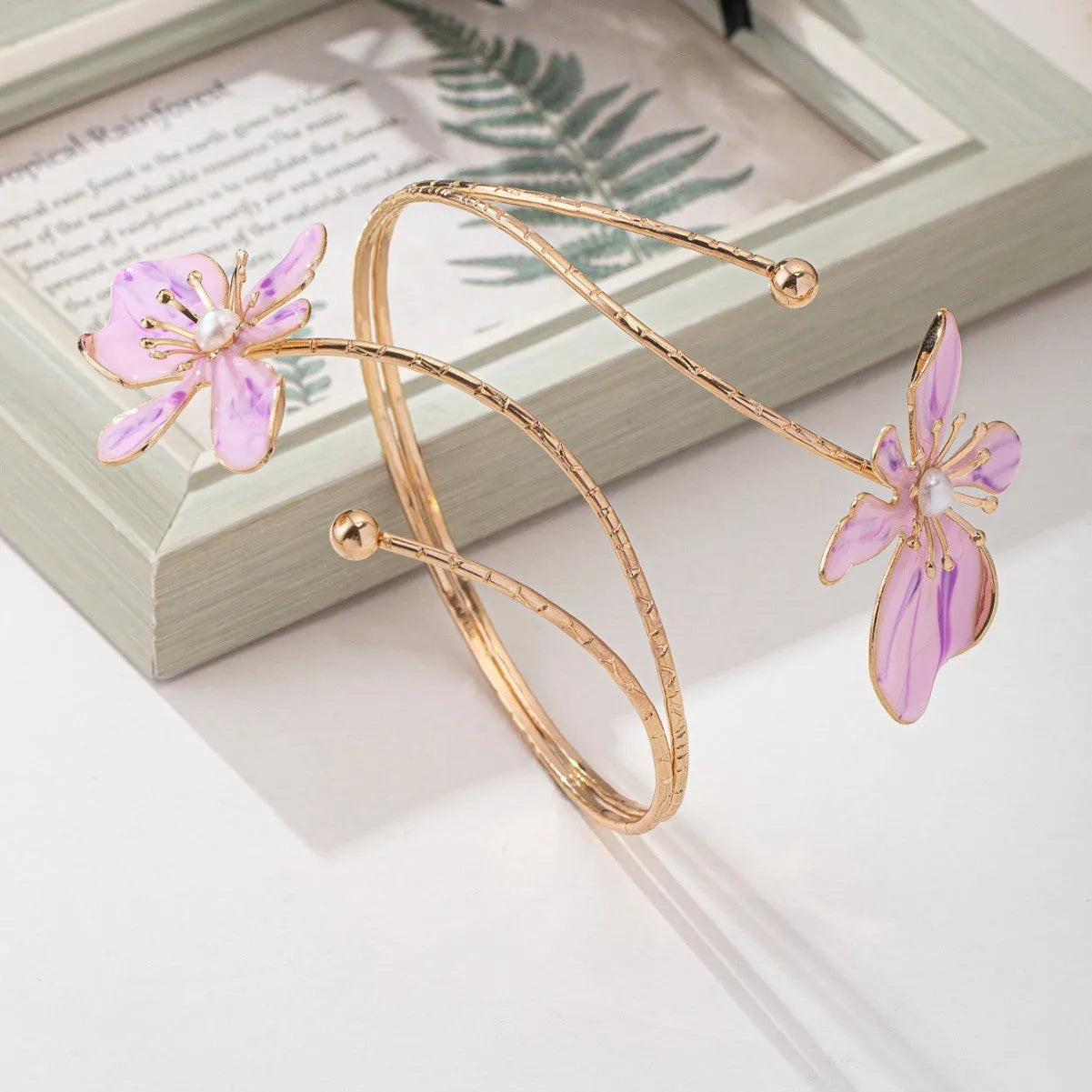 Close-up of a geometric hollow pattern alloy armband bracelet in pink, showing adjustable closure.