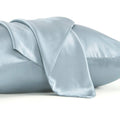 Solid colour mulberry silk envelope pillowcase in dark grey on a bed.