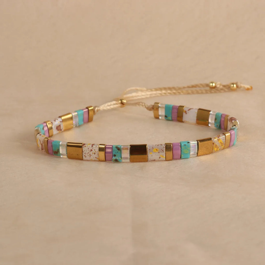 Geometric pull bead bracelet in milky white glass beads on a wrist.