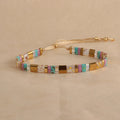 Geometric pull bead bracelet in milky white glass beads on a wrist.