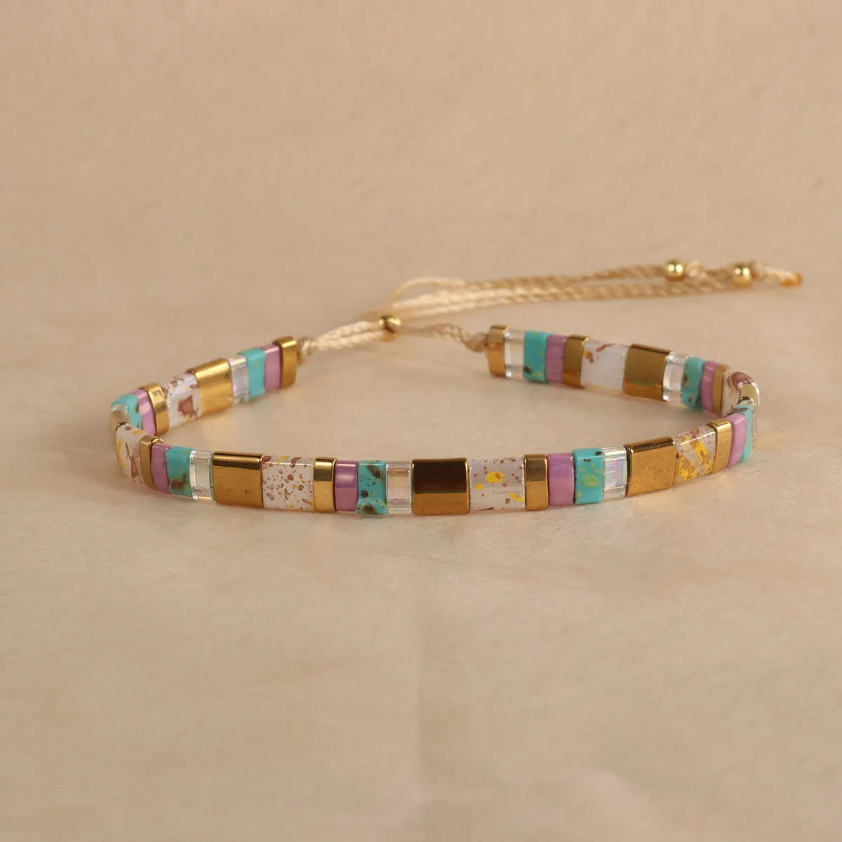 Geometric pull bead bracelet in milky white glass beads on a wrist.