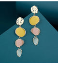 A pair of thin sterling silver stud earrings with Morandi-coloured wafer discs featuring an oil-drip texture.