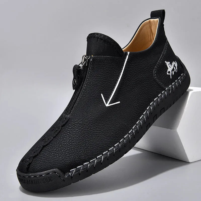 Men's black leather zip-up boots with round toe and hand-stitched rubber sole on a white background.