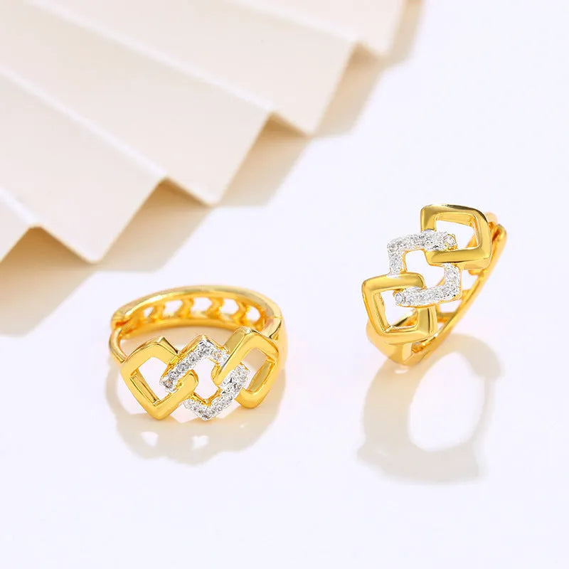 A pair of gold geometric earrings with a hollow out design and clip-on fastening.