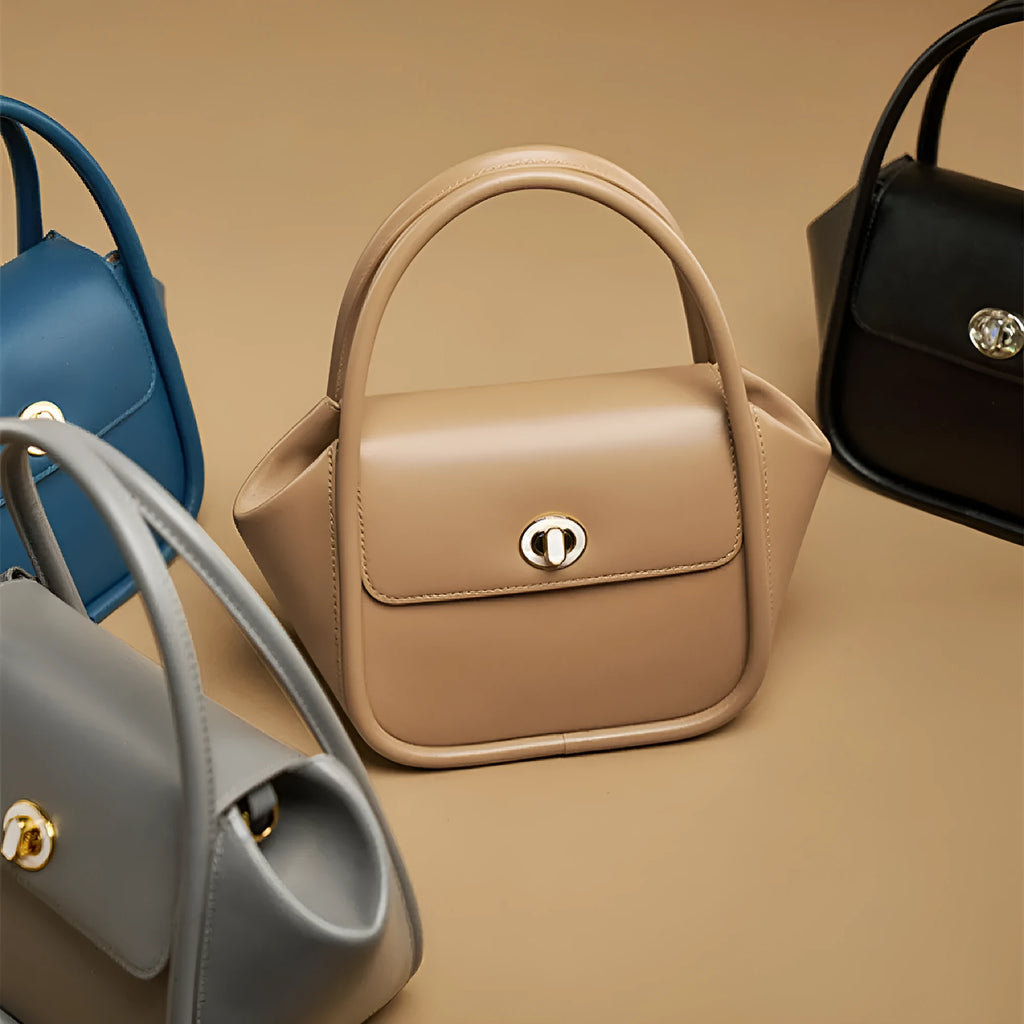 Women's leather wing-shaped tote bag with buckle closure in blue, grey, black, or brown colour options