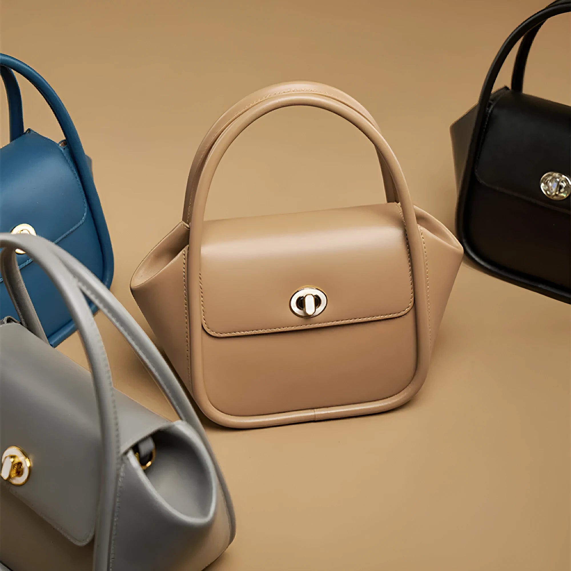 Women's leather wing-shaped tote bag with buckle closure in blue, grey, black, or brown colour options
