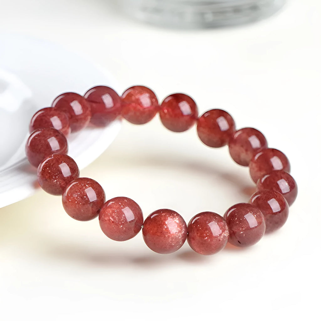 Natural red strawberry quartz crystal bracelet with geometric cut beads, shown in unisex styling.