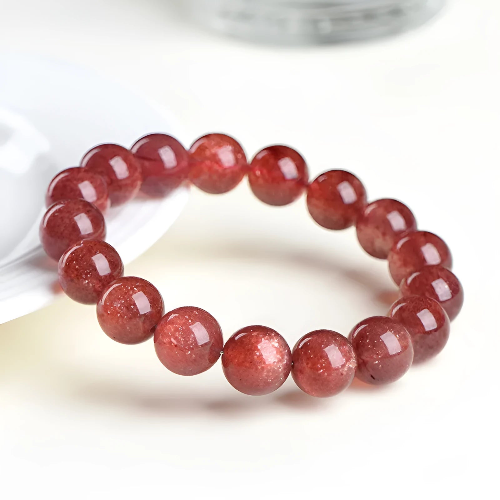Natural red strawberry quartz crystal bracelet with geometric cut beads, shown in unisex styling.