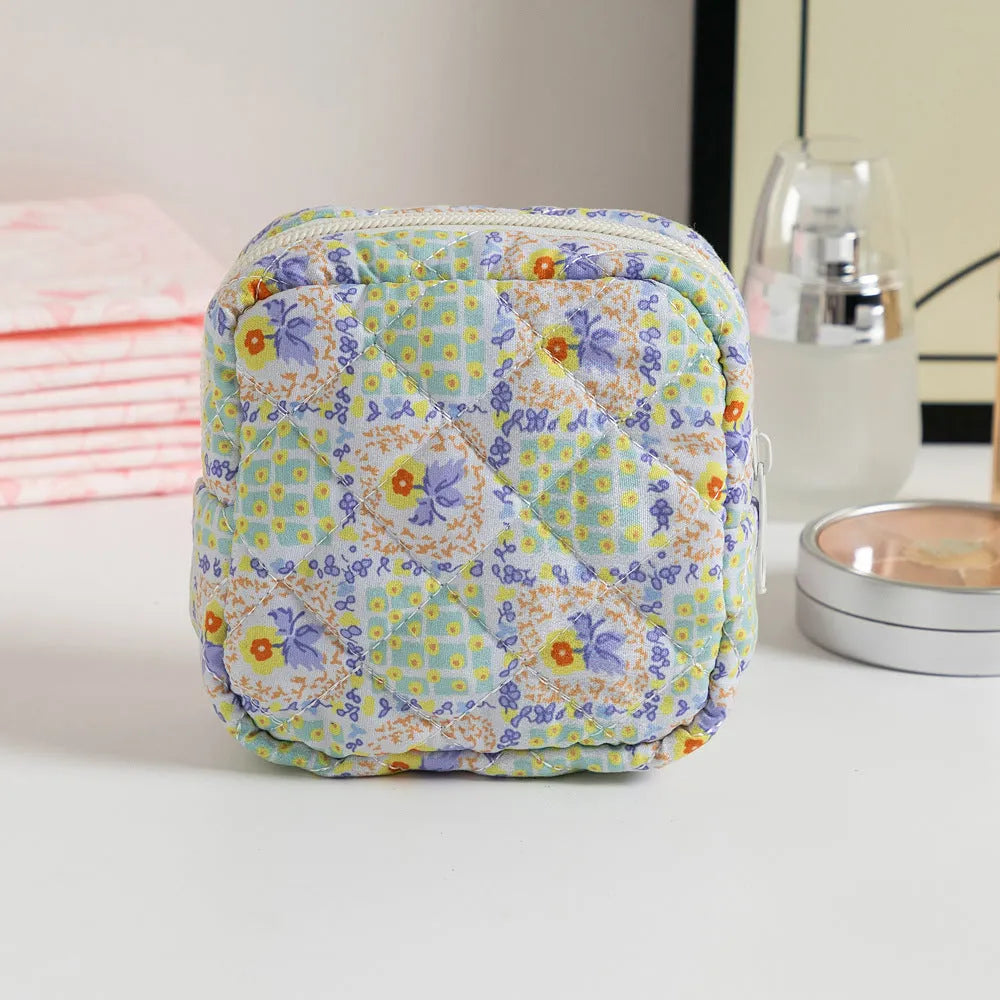 Yellow floral polyester key storage bag with sewing thread detail next to red small flower design variant.