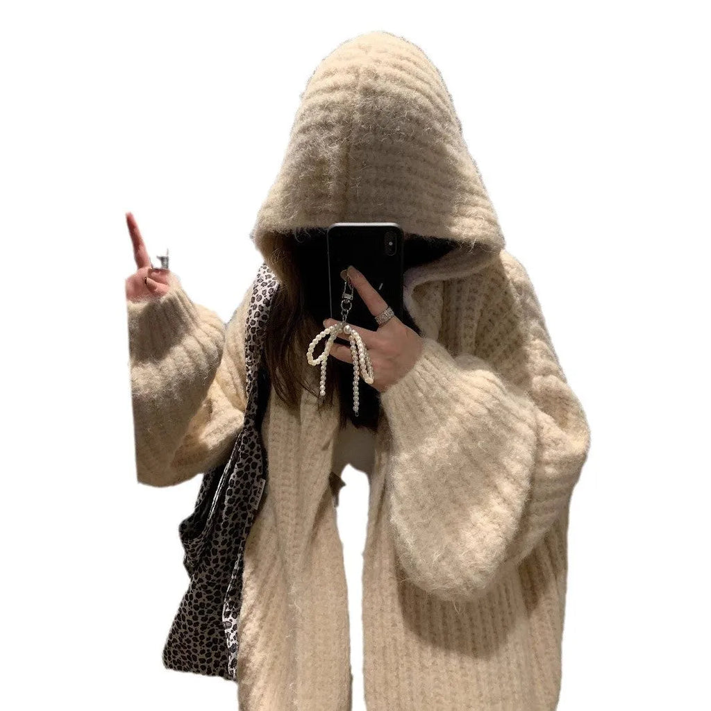 Woman wearing a loose-fit, chunky knit hooded cardigan in a macaron colour.