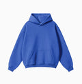 Man wearing a loose-fit grey terry cotton hooded sweater with drop-shoulder sleeves.