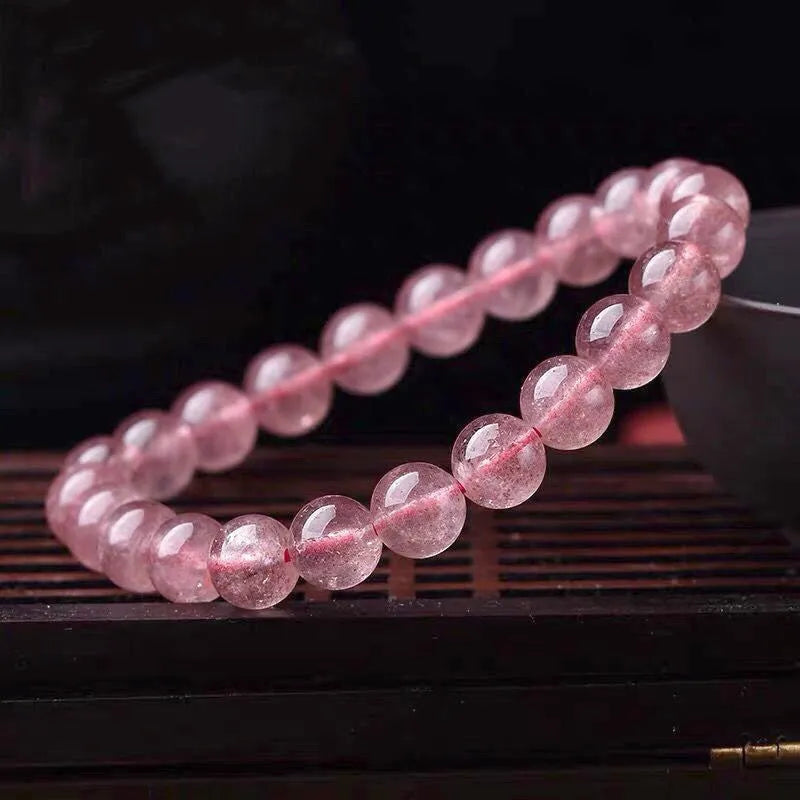 Women's strawberry quartz bracelet with polished beads in 6mm, 8mm, or 10mm sizes