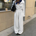 White striped wide-leg casual trousers with a zip closure on a hanger.