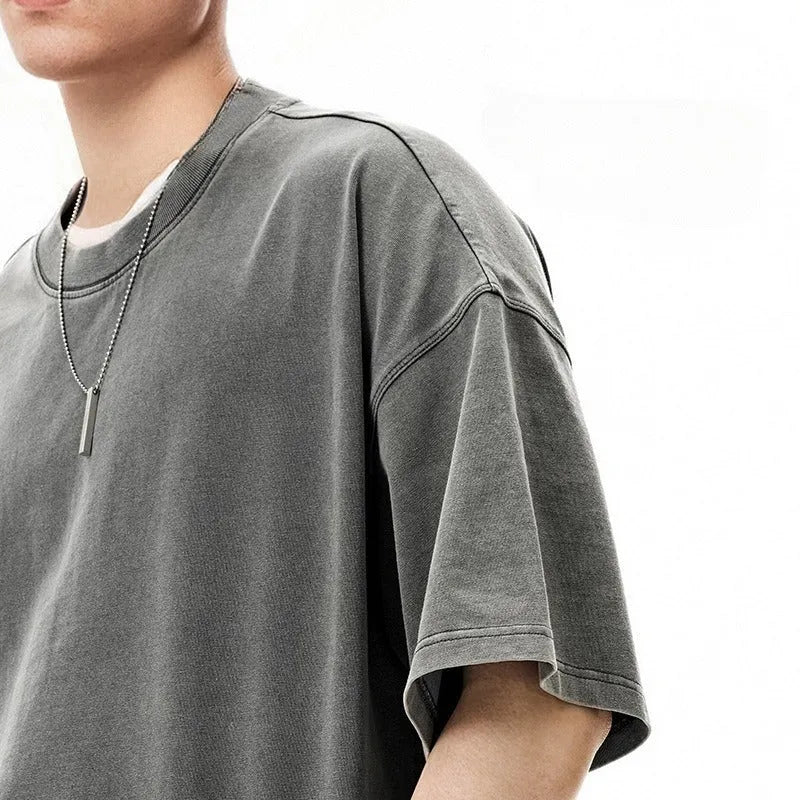 Men's vintage-style light khaki cotton t-shirt with a loose fit and drop-shoulder sleeves on a hanger.