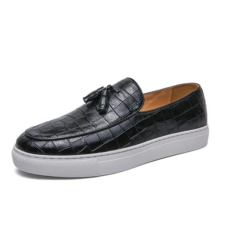 Men's black tassel slip-on sneakers with a round toe and rubber sole on a white background.