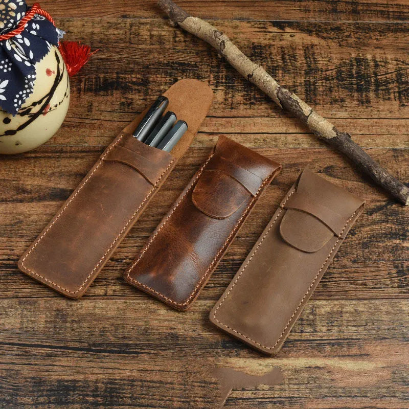 Brown leather pencil case with zip opening on a plain background