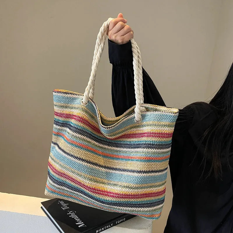 Blue straw woven nylon shoulder bag with a single strap and large main compartment