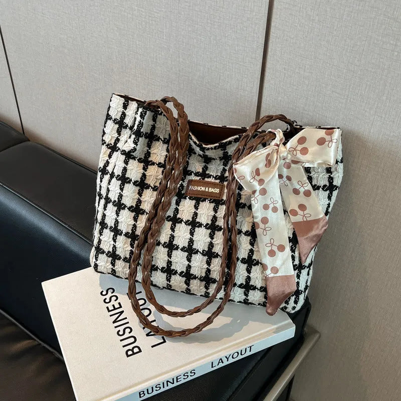 Black woven wool shoulder bag with horizontal square design showing internal organisation pockets and exterior sandwich compartment