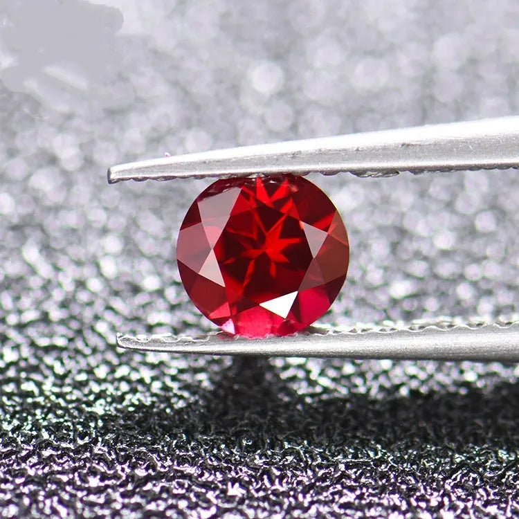 Loose cultivated pigeon blood red ruby gemstone in a princess cut on a grey background.