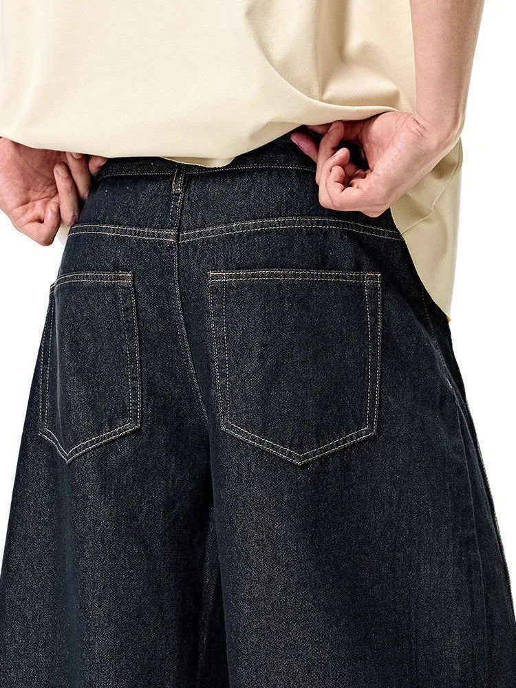 Men's original cow colour wide leg denim trousers laid flat showing mid-waist and relaxed leg cut