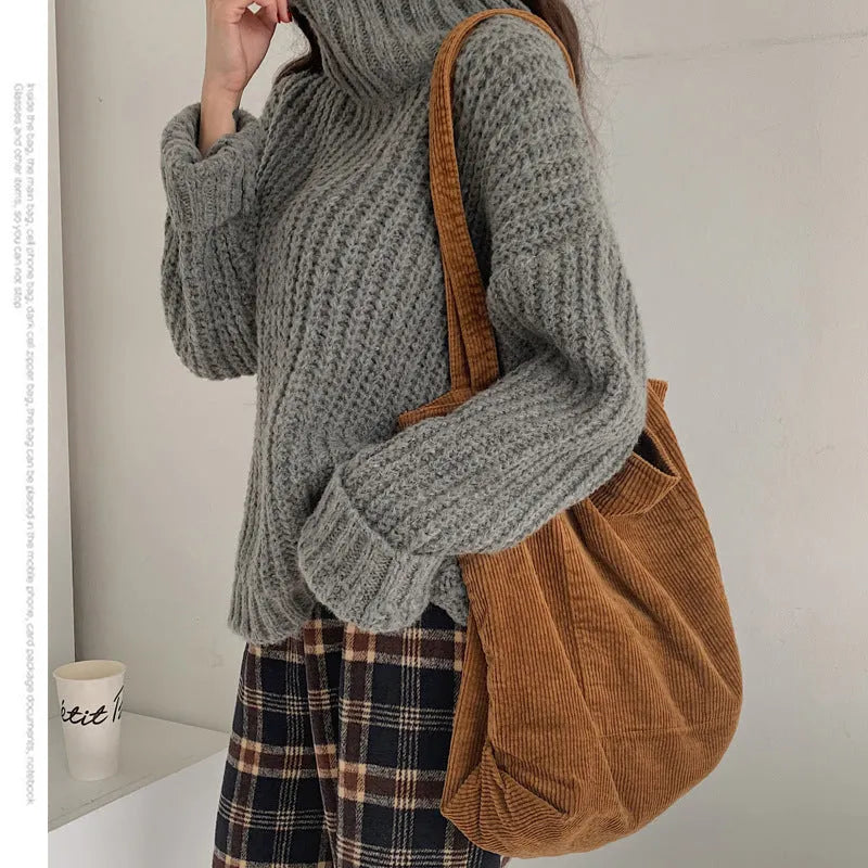 Large corduroy tote bag with soft handle, pleated detailing, and interior zipper pocket. Colour: black.