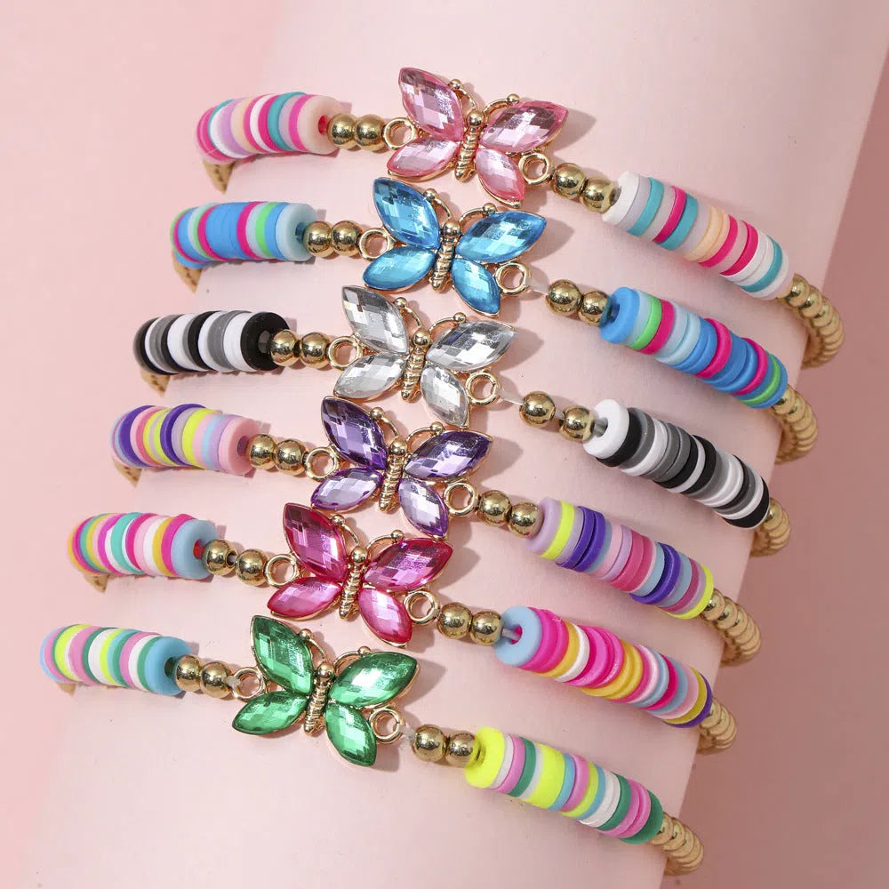 Children's polymer clay bracelet with dinosaur bead theme on a white background