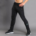 Slim-fit polyester running trousers with colour-changing reflective printing and zip pocket, black, front view