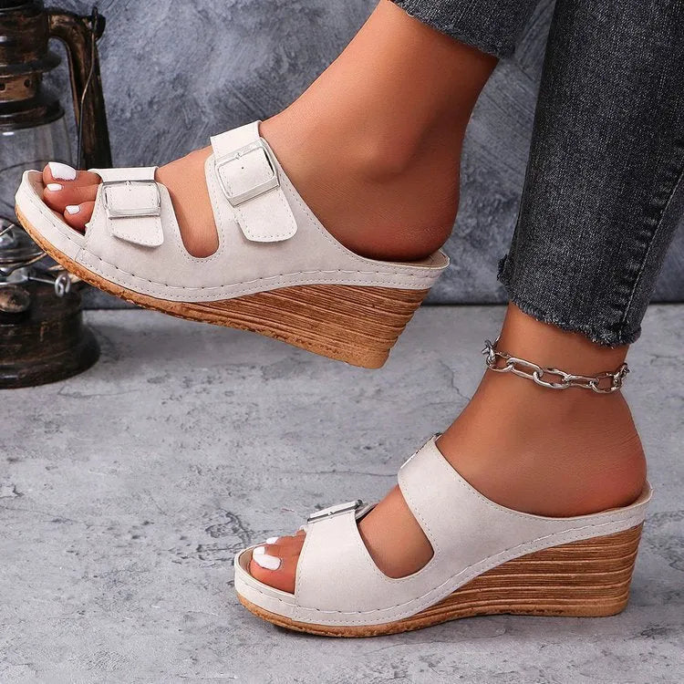 Women's creamy-white beach slippers with an outer wedge belt buckle fastening.