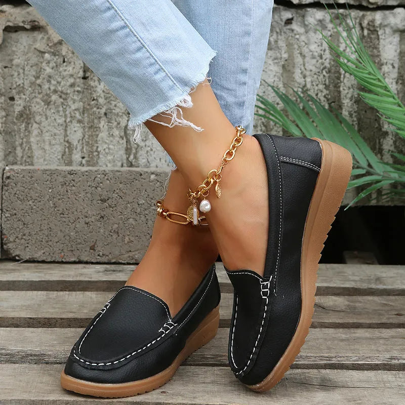 Women's black PU leather slip-on loafers with round toe and flat rubber sole