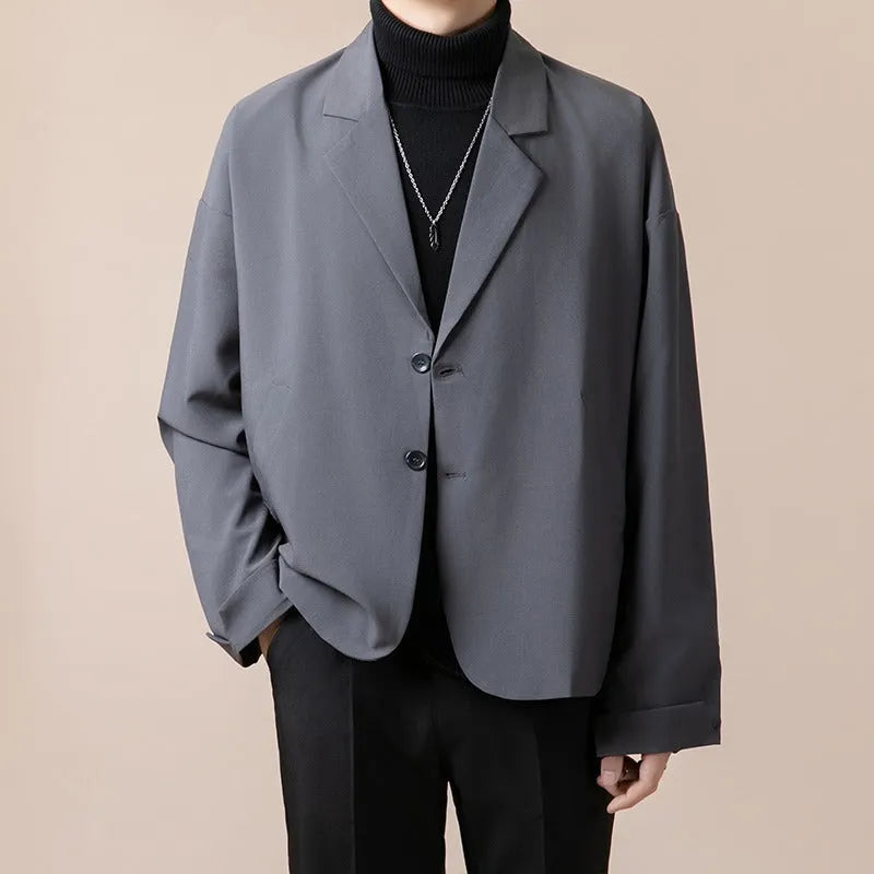 A man's loose fit suit jacket in a chemical fibre blend fabric, shown in one of four available colours.