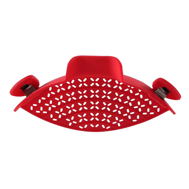 Silicone pot side drain stopper in black attached to saucepan rim with leak-proof edge
