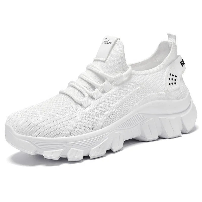 Women's white Flyknit running sneakers with round toe, flat heel, and thick PVC sole on a light background.