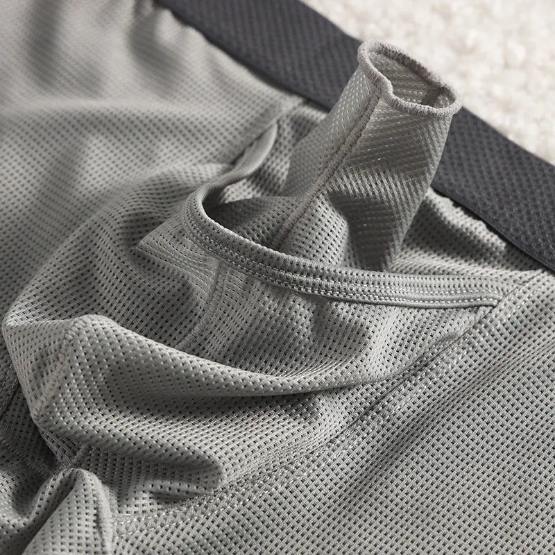 Men's solid colour ice silk boxer briefs with a low waist and mesh knit fabric.