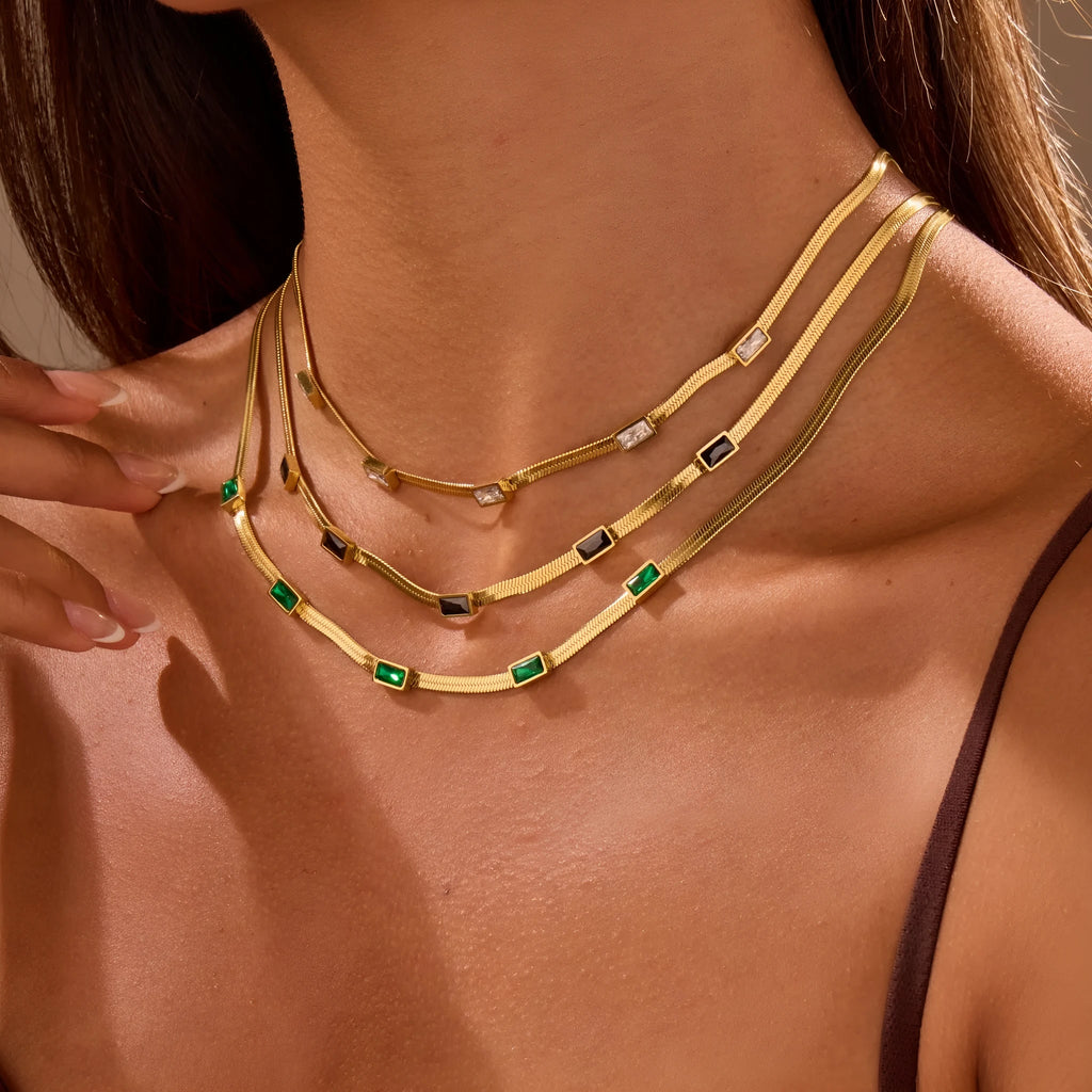 Geometric square zircon pendant on a flat stainless steel snake chain necklace in a gold colour finish.