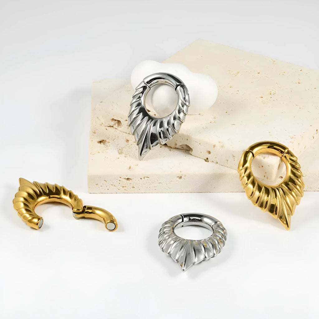 Stainless steel drop-shaped ear extender with round hanging egg and totem pattern detail.